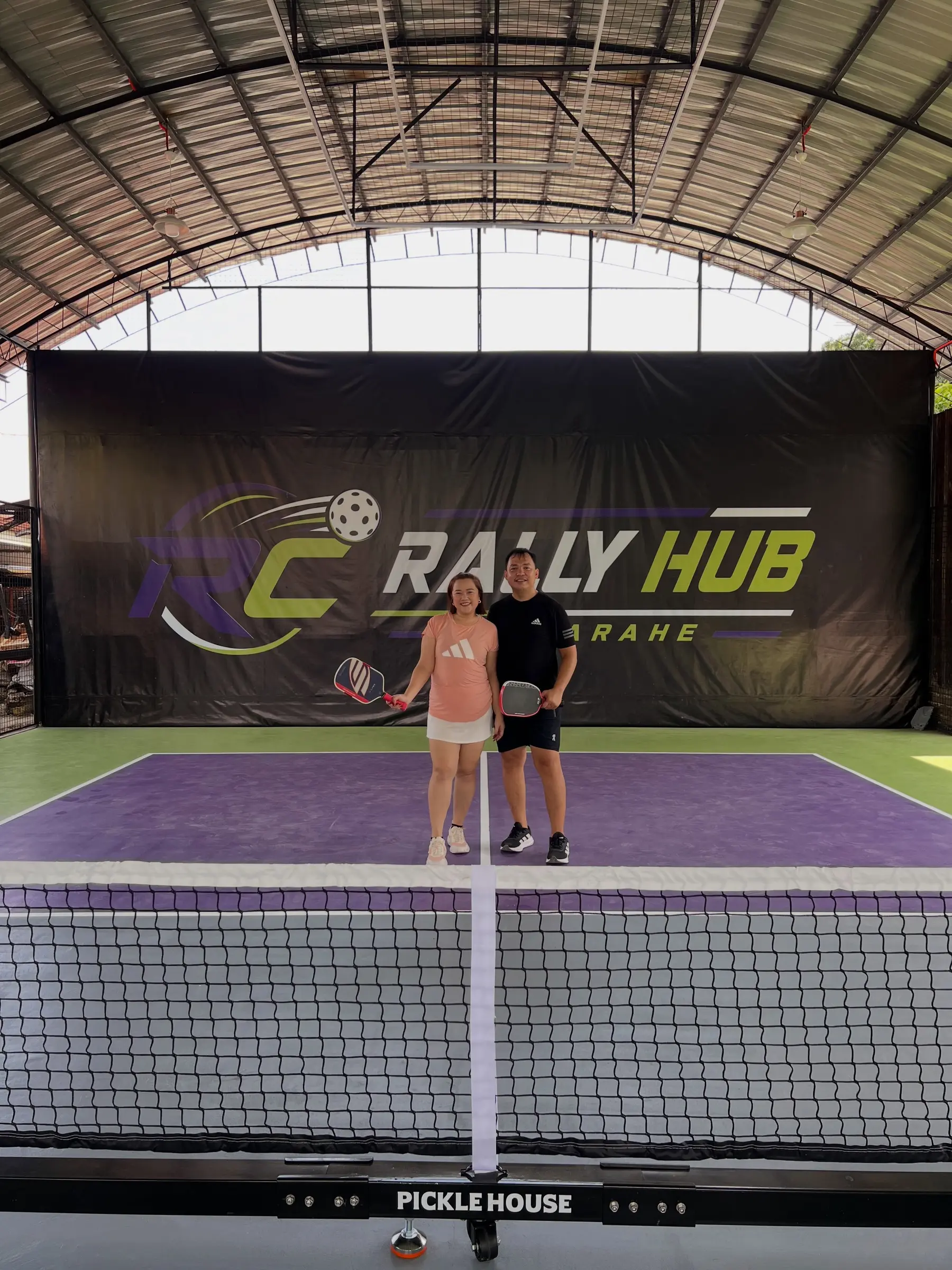 Two players posing with their paddles courtside, ready to learn pickleball basics